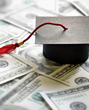 graduation cap on top of money